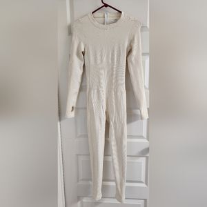Cream Ribbed Jumpsuit w/ thumb hole sleeves. Rear zip. Never worn.Compression. M
